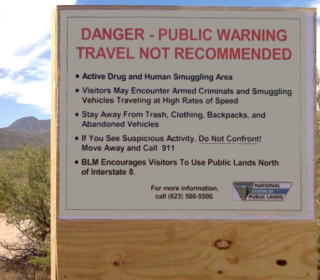 Arizona border sign: Danger - public warning. Travel not recommended. Active drug and human smuggling area. Armed criminals.